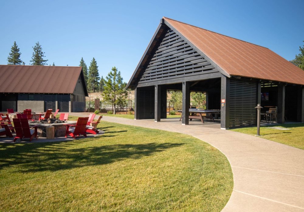 Park like structure with picnic tables and firepits with Adirondack chairs.