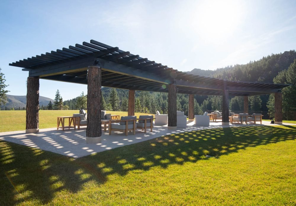 Commercial Landscaping by Gail Willey Landscaing in Reno Nevada. Large wooden pergola made from tree trunks with a seating area