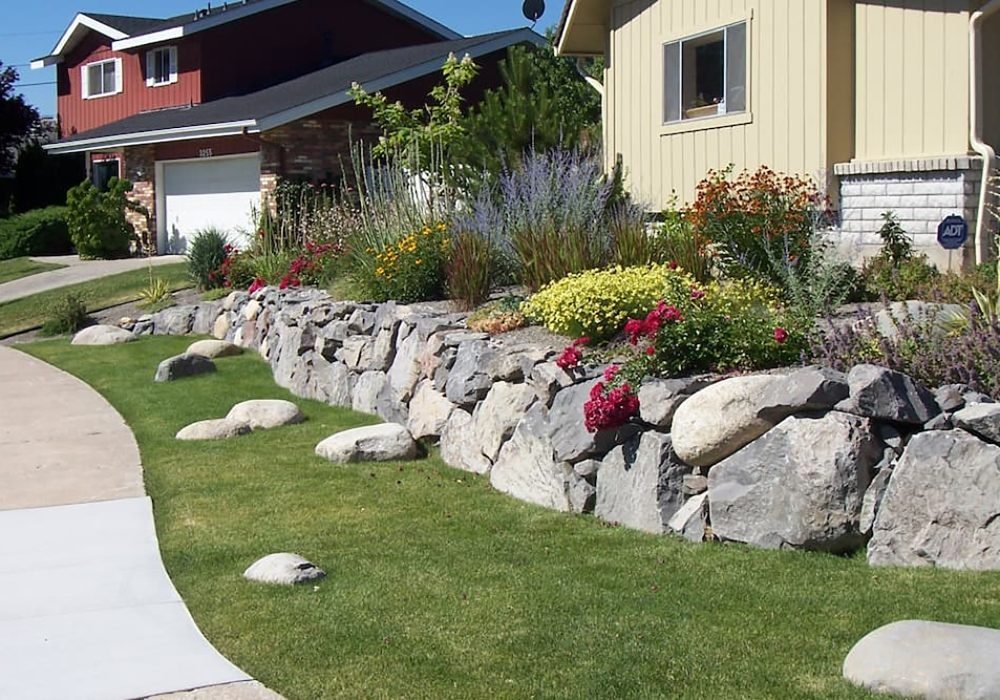 Drystack boulder retainer wall in residential.